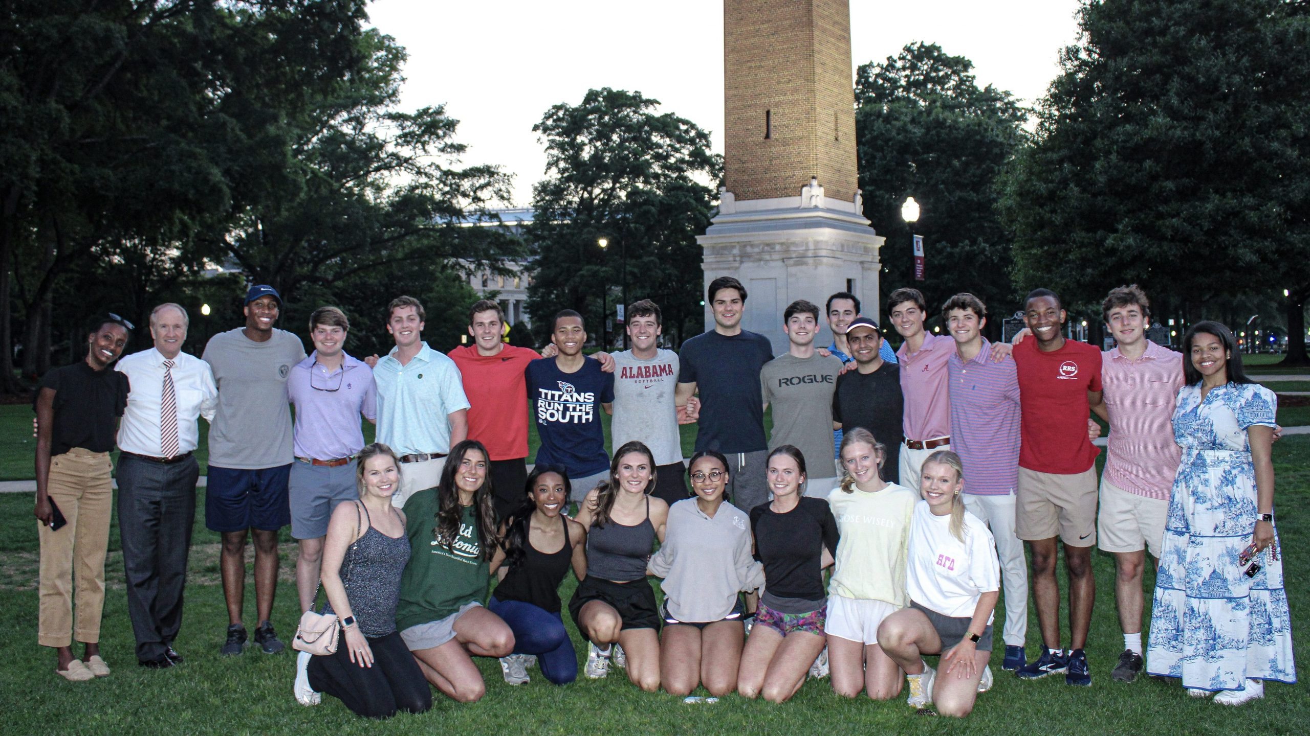 Capstone Men and Women posing for a photo on the quad in front of Denny Chimes with Dr. Stuart Bell